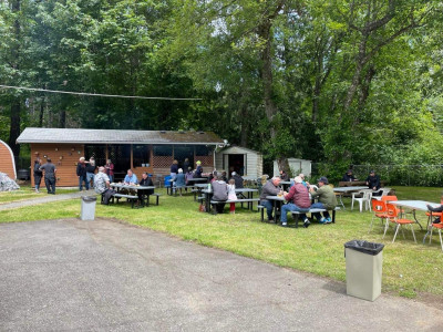 Fathers, daughters and sons sit down at the backyard tables to enjoy a hot dog or hamburger.